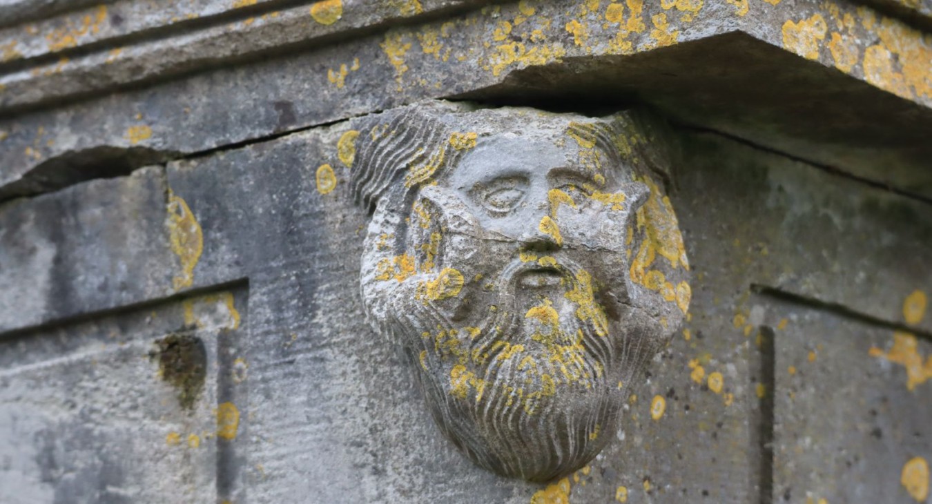 Head of a pan figure on a chest tomb in Section 8 of St. Josephs